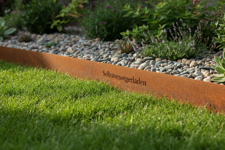 Rasenkante aus verrostetem Cortenstahl mit Schriftzug Selbstversorgerladen